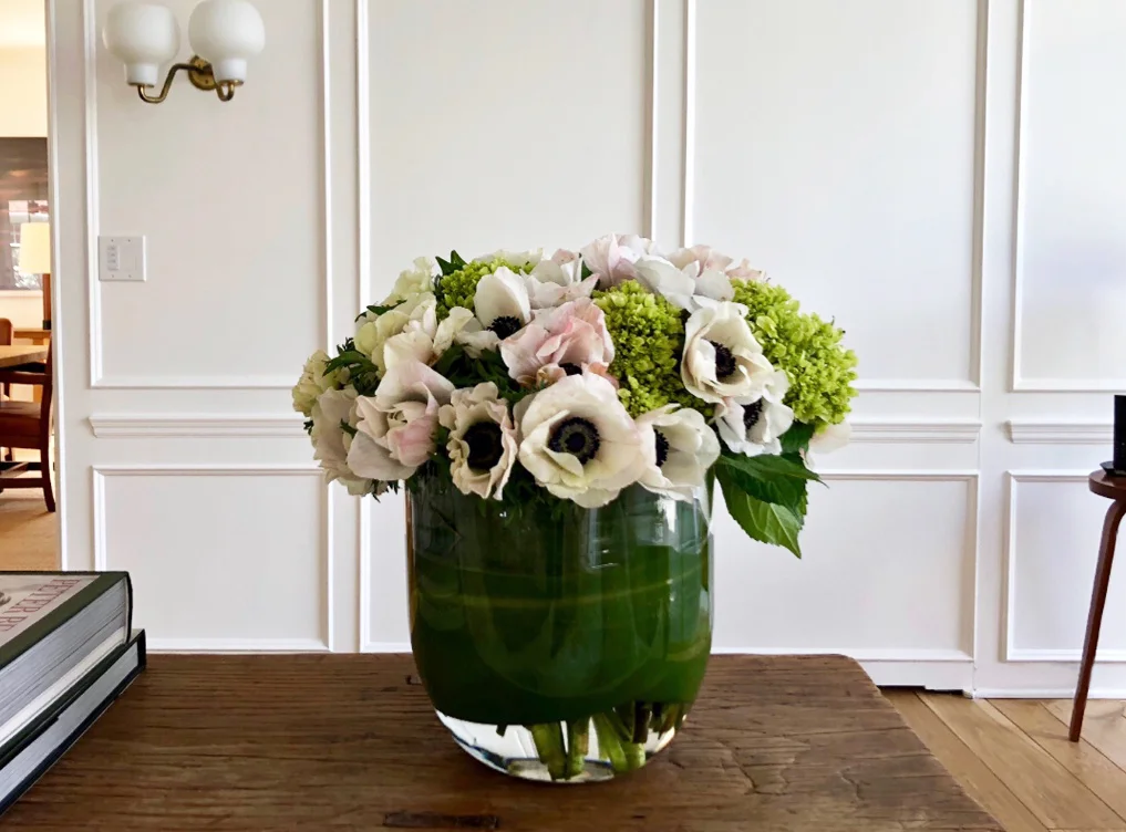 Anemones and hydrangea in a leaf-lined vase