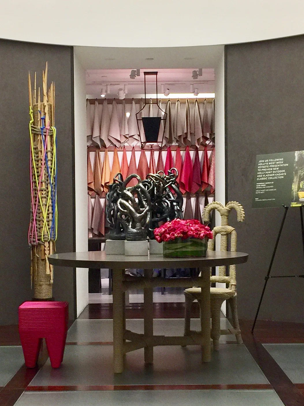 Towering branches and a low mound of roses bring height and softness to a curved gallery.