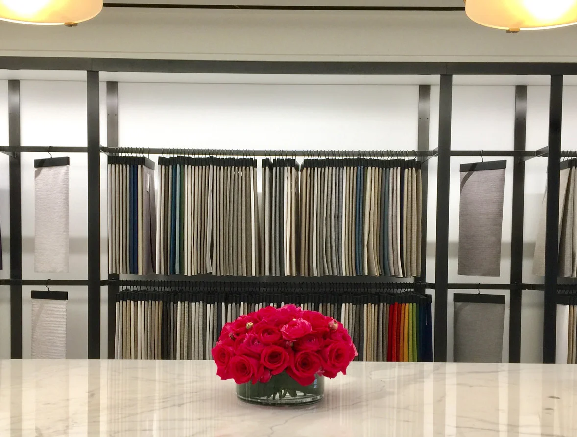 A low posy of red roses on marble in a textile showroom